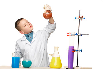 Image showing Little boy as chemist doing experiment with chemical fluid in the laboratory