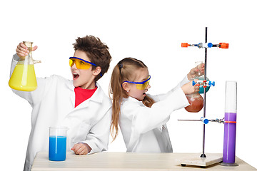 Image showing Two cute children at chemistry lesson making experiments