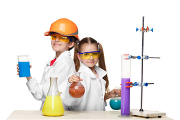 Image showing Two cute children at chemistry lesson making experiments