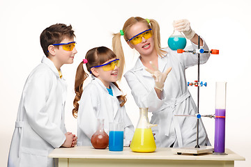 Image showing Teens and teacher of chemistry at  lesson making experiments