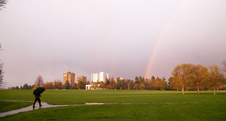 Image showing Rainbow Appears Over Park During Thunderstorm Pedestrian Umbrell