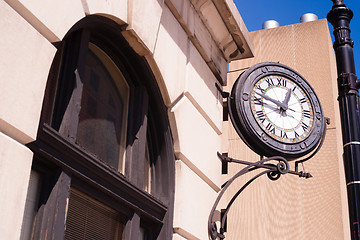 Image showing Community Clock Mounted on Building Close Corner Sidewalk