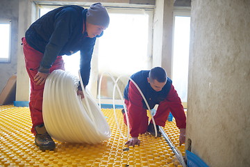 Image showing workers installing underfloor heating system