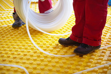 Image showing workers installing underfloor heating system