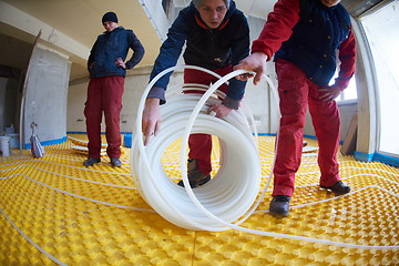 Image showing workers installing underfloor heating system