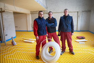 Image showing workers installing underfloor heating system