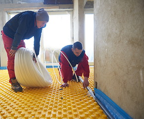 Image showing workers installing underfloor heating system