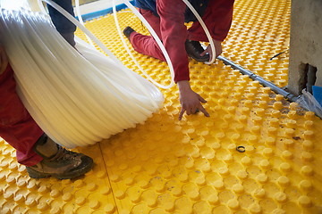 Image showing workers installing underfloor heating system