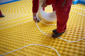 Image showing workers installing underfloor heating system