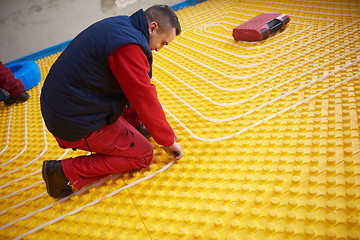 Image showing workers installing underfloor heating system