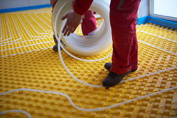 Image showing workers installing underfloor heating system