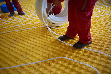 Image showing workers installing underfloor heating system