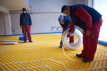 Image showing workers installing underfloor heating system