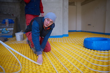 Image showing workers installing underfloor heating system