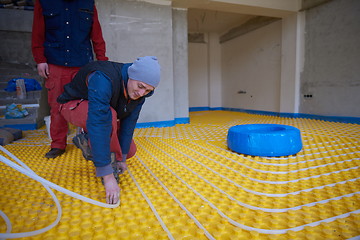 Image showing workers installing underfloor heating system