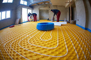 Image showing workers installing underfloor heating system