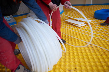 Image showing workers installing underfloor heating system