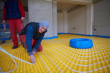 Image showing workers installing underfloor heating system