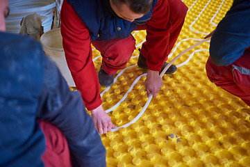 Image showing workers installing underfloor heating system