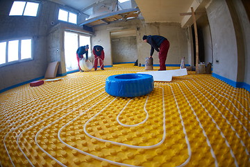 Image showing workers installing underfloor heating system