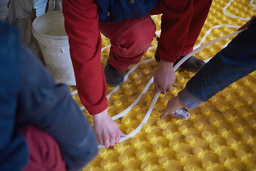 Image showing workers installing underfloor heating system