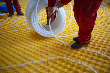 Image showing workers installing underfloor heating system