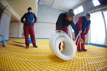 Image showing workers installing underfloor heating system