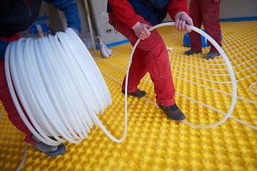 Image showing workers installing underfloor heating system