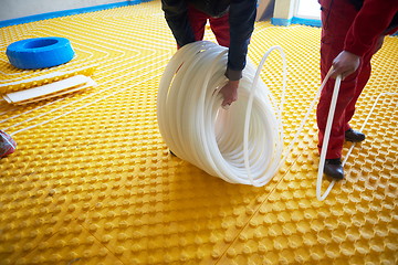 Image showing workers installing underfloor heating system