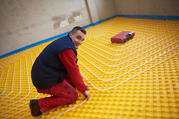 Image showing workers installing underfloor heating system