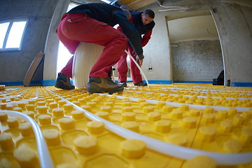 Image showing workers installing underfloor heating system