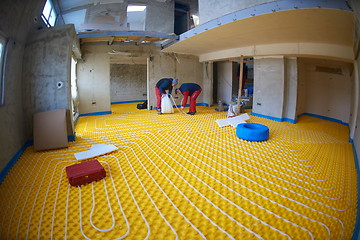 Image showing workers installing underfloor heating system