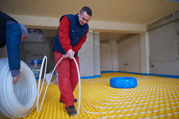 Image showing workers installing underfloor heating system