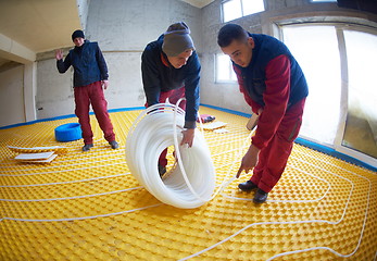 Image showing workers installing underfloor heating system