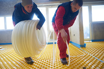 Image showing workers installing underfloor heating system