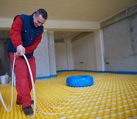 Image showing workers installing underfloor heating system