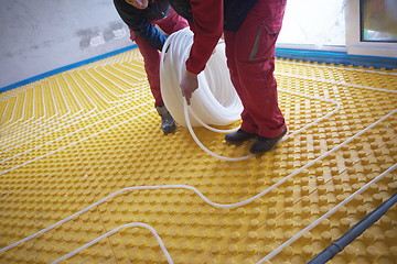 Image showing workers installing underfloor heating system