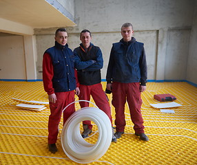 Image showing workers installing underfloor heating system