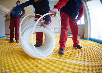 Image showing workers installing underfloor heating system