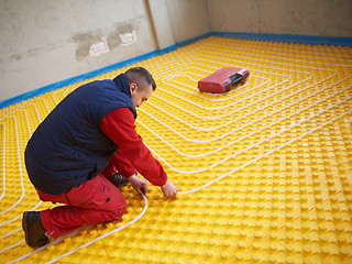 Image showing workers installing underfloor heating system