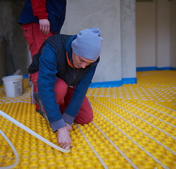 Image showing workers installing underfloor heating system