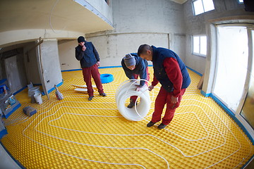 Image showing workers installing underfloor heating system