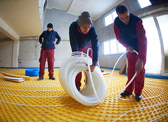 Image showing workers installing underfloor heating system