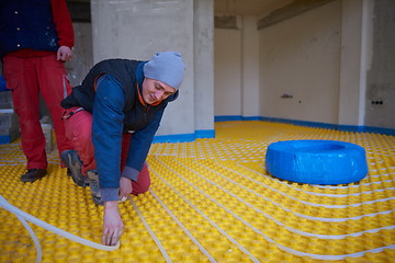 Image showing workers installing underfloor heating system