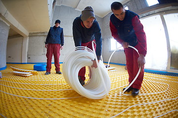 Image showing workers installing underfloor heating system