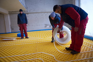 Image showing workers installing underfloor heating system