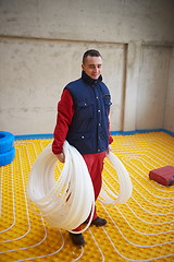 Image showing workers installing underfloor heating system