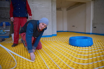 Image showing workers installing underfloor heating system