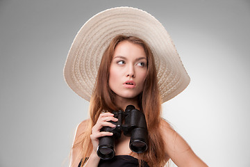 Image showing Young woman in hat with binoculars
