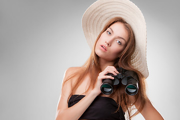 Image showing Young woman in hat with binoculars